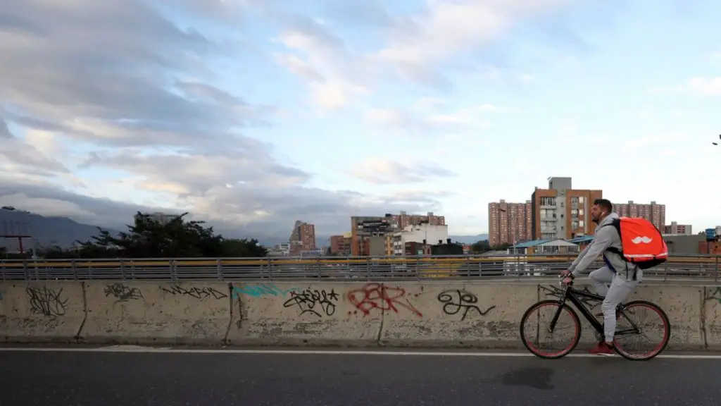 Venezuelan bicycle courier Samuel Romero pedals through Bogotá, Colombia, at the start of his work day on Wednesday, July 17, 2019. Critics of the app say that a large number of couriers have basically become full-time workers, and lawmakers in Colombia and Argentina are considering regulations to boost protection for the workers.
